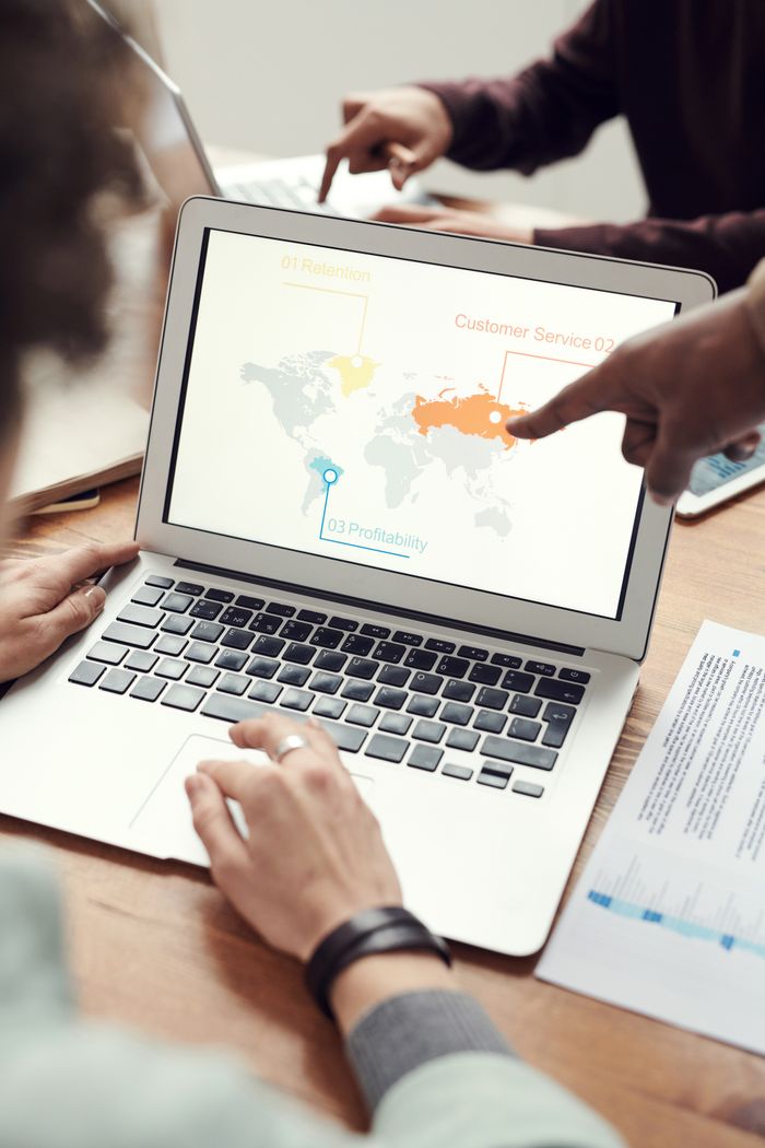 Mastering the First Impression: Your intriguing post title goes here Colleagues in discussion around a laptop showing a global business presentation.