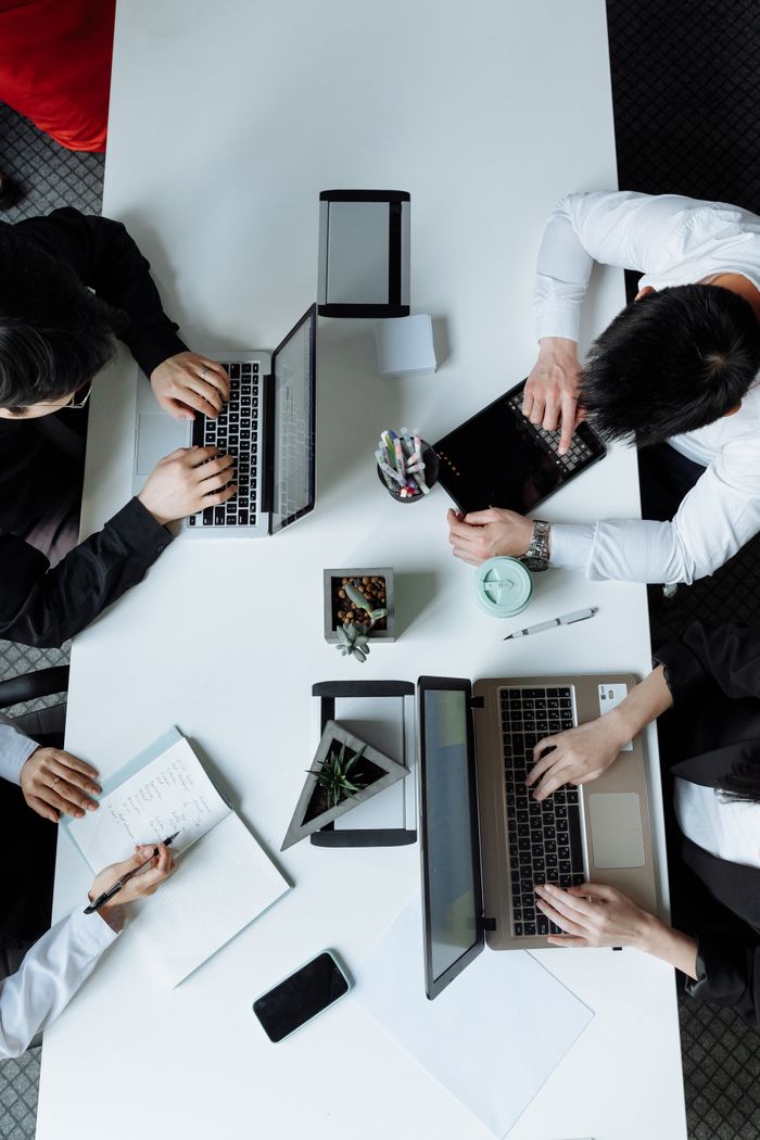 The Art of Drawing Readers In: Your attractive post title goes here A diverse team working together in a modern office setting, focusing on laptops and collaboration.
